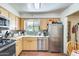 Kitchen features stainless steel appliances, a window above the sink, and wood cabinetry at 5501 E Dallas St, Mesa, AZ 85205