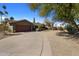 Landscaped front yard with a curved driveway leading to a single-story home at 5820 N 83Rd St, Scottsdale, AZ 85250