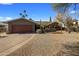 Single-story home with a brown garage door and gravel driveway at 5820 N 83Rd St, Scottsdale, AZ 85250