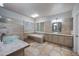 Bright bathroom featuring a large tub, dual vanities with vessel sinks, and stylish tile floors and walls at 6102 E Sonoran Trl, Scottsdale, AZ 85266