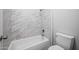 Bright bathroom featuring a bathtub with marble tile surround and a white toilet at 6102 E Sonoran Trl, Scottsdale, AZ 85266