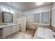 Bright bathroom featuring a large tub, dual vanities with vessel sinks, and stylish tile floors and walls at 6102 E Sonoran Trl, Scottsdale, AZ 85266