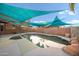 Backyard featuring a private pool, shaded by multiple sunshades and desert landscaping at 6102 E Sonoran Trl, Scottsdale, AZ 85266