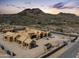 Expansive aerial view of a home under construction with mountain backdrop and desert landscape at sunset at 6109 E Maverick Rd, Paradise Valley, AZ 85253