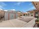 Well kept yard with a covered patio, rock landscaping, shed for storage, and block wall for privacy at 7950 E Lakeview Ave, Mesa, AZ 85209