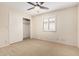 This bedroom features neutral carpet, ceiling fan, and closet with sliding doors at 7950 E Lakeview Ave, Mesa, AZ 85209