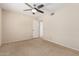 Large bedroom with neutral carpet, ceiling fan, and an attached bathroom at 7950 E Lakeview Ave, Mesa, AZ 85209