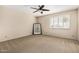 This carpeted bedroom features a ceiling fan and window with white shutters at 7950 E Lakeview Ave, Mesa, AZ 85209