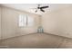 This carpeted bedroom features a ceiling fan and window with white shutters at 7950 E Lakeview Ave, Mesa, AZ 85209