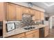 Kitchen showcasing stone countertops, tiled backsplash and light wood cabinetry at 7950 E Lakeview Ave, Mesa, AZ 85209