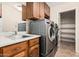 Laundry room featuring stainless steel washer and dryer units, with a sink and cabinetry at 7950 E Lakeview Ave, Mesa, AZ 85209
