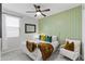 Charming bedroom with a white bed frame, green accent pillows, and a statement wall at 10037 E Rubidium Ave, Mesa, AZ 85212