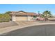 House exterior showcasing a tan brick facade, a two car garage and desert landscaping at 10312 W Sierra Dawn Dr, Sun City, AZ 85351