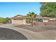 Front view of a tan brick ranch home with a palm tree and gravel driveway at 10312 W Sierra Dawn Dr, Sun City, AZ 85351