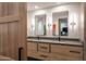 Bathroom with dual sinks, light wood cabinets, and black accents at 10598 E Fernwood Ln, Scottsdale, AZ 85262