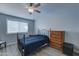 Bedroom with dark blue bedding and wood dresser at 10851 N Fairway E Ct, Sun City, AZ 85351