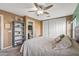 Serene bedroom with ceiling fan, bookshelf, and en-suite bathroom at 11608 W Oglesby Ave, Youngtown, AZ 85363