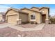 Tan house with a two-car garage, walkway, and landscaping at 11608 W Oglesby Ave, Youngtown, AZ 85363