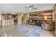 Open living room and kitchen with tile floors and a wooden accent wall at 11608 W Oglesby Ave, Youngtown, AZ 85363