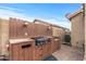 Outdoor kitchen with built-in grill and storage at 11608 W Oglesby Ave, Youngtown, AZ 85363