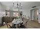 Bright dining area with a round table and four chairs, stylish chandelier, and hardwood floors at 12838 N 148Th Ln, Surprise, AZ 85379