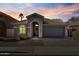 Evening view of single story home with a two-car garage at 12838 N 148Th Ln, Surprise, AZ 85379