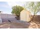 Backyard storage shed with new landscaping along block fencing and a tall shade tree at 14019 N 51St Dr, Glendale, AZ 85306