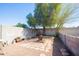 Private backyard featuring a fireplace, a mature tree, and a gravel walking area at 14019 N 51St Dr, Glendale, AZ 85306