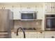 Close-up of the kitchen highlighting stainless steel appliances and mosaic tile backsplash at 14019 N 51St Dr, Glendale, AZ 85306