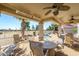 Covered patio with seating area, fans, and heaters overlooking the pool at 15725 W Linksview Dr, Surprise, AZ 85374