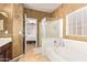 Clean bathroom with shower and tub, plus view into bedroom at 15839 W Calavar Rd, Surprise, AZ 85379