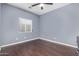 Simple bedroom with dark hardwood floors and ceiling fan at 15839 W Calavar Rd, Surprise, AZ 85379