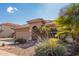 One-story house with a tan exterior and a landscaped front yard with palm trees at 15839 W Calavar Rd, Surprise, AZ 85379