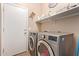 Bright laundry room features washer, dryer, and shelving at 15839 W Calavar Rd, Surprise, AZ 85379