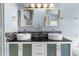 Stylish bathroom featuring double sinks, a black countertop, modern lighting, and sleek fixtures at 16241 S 40Th Way, Phoenix, AZ 85048