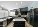 Modern kitchen with dark cabinetry, marble countertops, stainless steel appliances, and a kitchen island with seating at 16241 S 40Th Way, Phoenix, AZ 85048