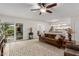 Living room with brown couch, ceiling fan, and view to backyard at 16420 N Scorpion Dr, Fountain Hills, AZ 85268