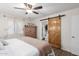 Main bedroom features king bed, barn door to bathroom, and wood accents at 16420 N Scorpion Dr, Fountain Hills, AZ 85268