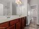 Double vanity bathroom with dark wood cabinets and a mirror at 17962 W Vogel Ave, Waddell, AZ 85355