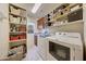 Bright laundry room with washer, dryer, and ample shelving at 18212 W East Wind Ave, Goodyear, AZ 85338