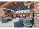 Stone fireplace and seating under a wooden pergola at 18212 W East Wind Ave, Goodyear, AZ 85338