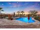 Inviting kidney-shaped pool with lounge chairs and a sunset view at 18212 W East Wind Ave, Goodyear, AZ 85338