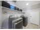 Bright laundry room with washer, dryer, and ample shelving at 18239 N 46Th St, Phoenix, AZ 85032