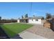 Expansive backyard with lush green lawn, covered patio, and low maintenance gravel area at 1865 W 3Rd Pl, Mesa, AZ 85201