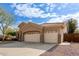 Tan house with three car garage and desert landscaping at 1875 E Stephens Dr, Tempe, AZ 85283