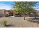 Spacious backyard with covered patio, built-in grill, and gravel landscaping at 20533 N Sequoia Crest Dr, Surprise, AZ 85387