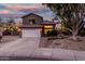 Two-story house with landscaped yard, driveway, and white garage door at dusk at 21054 N 74Th Ln, Glendale, AZ 85308