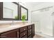 Bathroom with double sinks, dark wood cabinets, and a shower at 21362 E Puesta Del Sol Rd, Queen Creek, AZ 85142