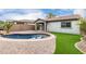 Kidney shaped pool with brick coping and artificial turf at 21362 E Puesta Del Sol Rd, Queen Creek, AZ 85142