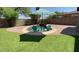 Inviting pool area with an umbrella and chairs on a well-maintained lawn at 21362 E Puesta Del Sol Rd, Queen Creek, AZ 85142